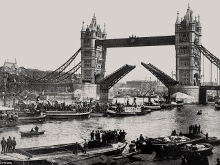 Historic image of Tower Bridge and the upper Pool of London filled with barges