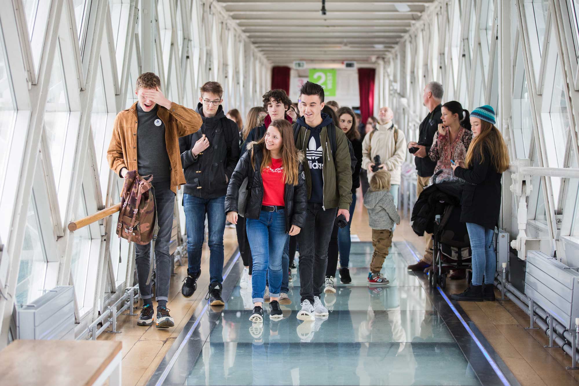 A group of visitors walk along the Glass Floor