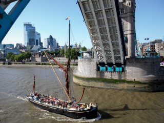 A boat goes through Tower Bridge as the bascules are raised
