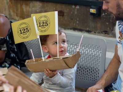 Small boy builds a boat of cardboard for our celebratory flotilla